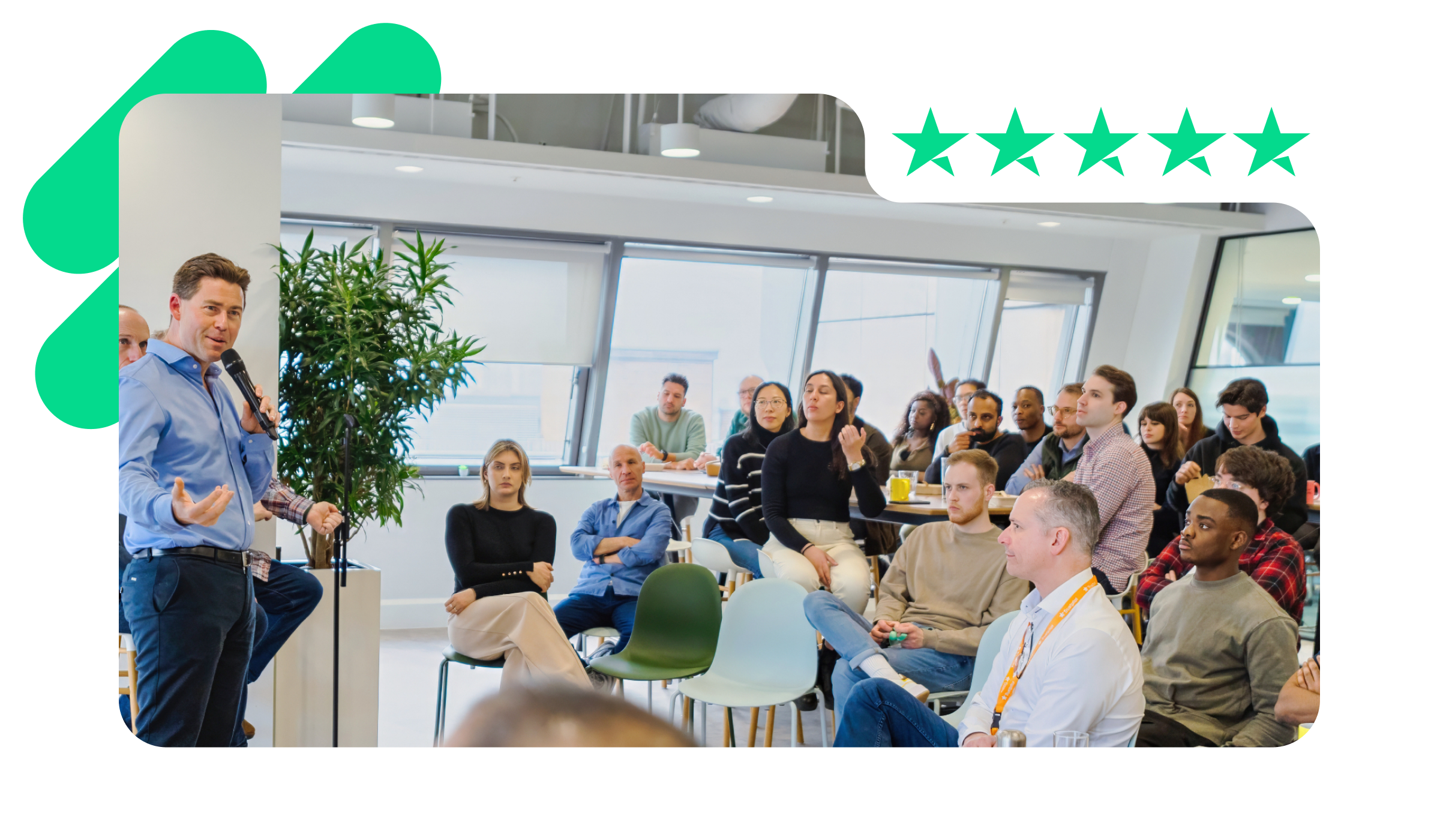 A photo of Adrian Blair, CEO at Trustpilot, presenting in a company meeting